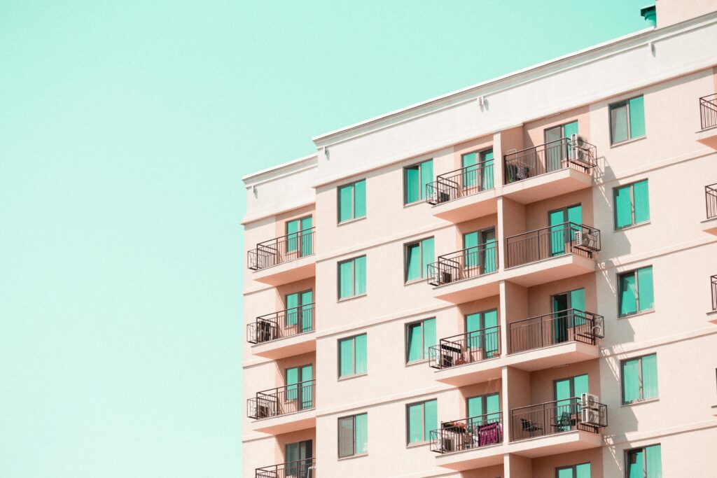 pexels photo 33278508 33278508 Modern apartment building facade with balconies under a clear blue sky.